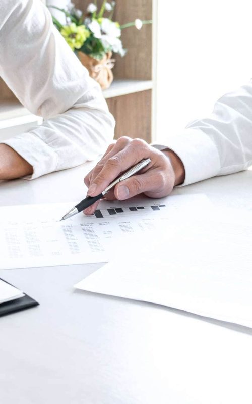 Professionals reviewing insurance documents and planning employee benefit solutions at a desk